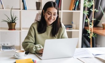 a imagem mostra uma moça em um escritório home-office trabalhando em frente a um notebook. A imagem faz referência ao Google Colab.