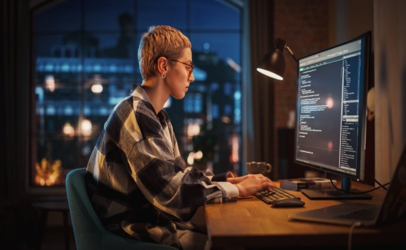 mulher programadora em frente a uma tela de computador