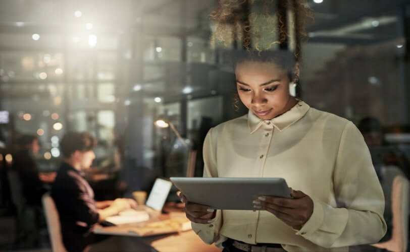 mulher em um escritório olhando um tablet