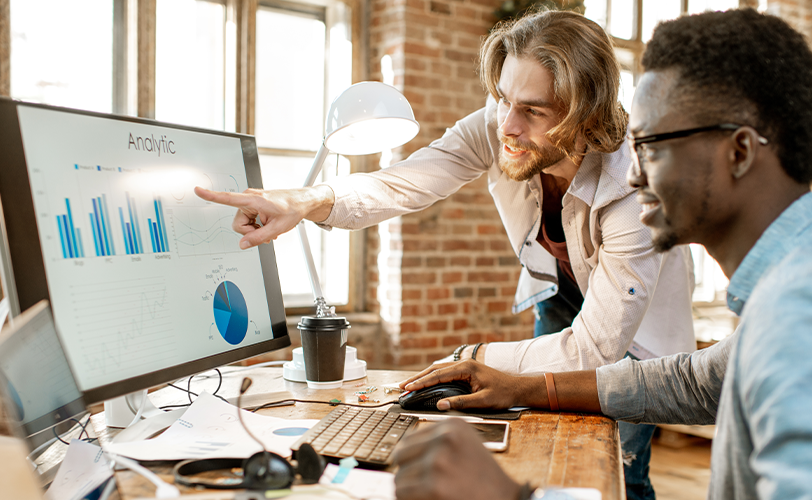 Dois empreendedores analisando dados na tela de um computador