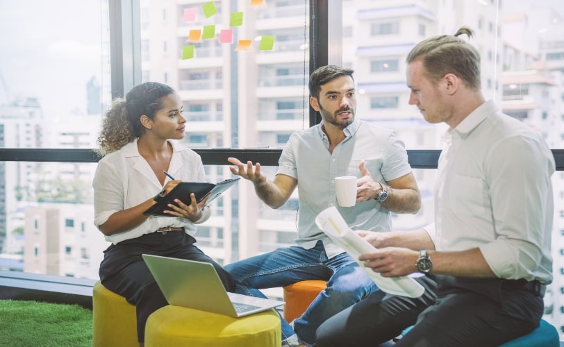 Três pessoas conversando em um escritório sobre inteligência artificial e estratégias de SEO.