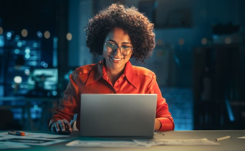 mulher usando computador e sorrindo