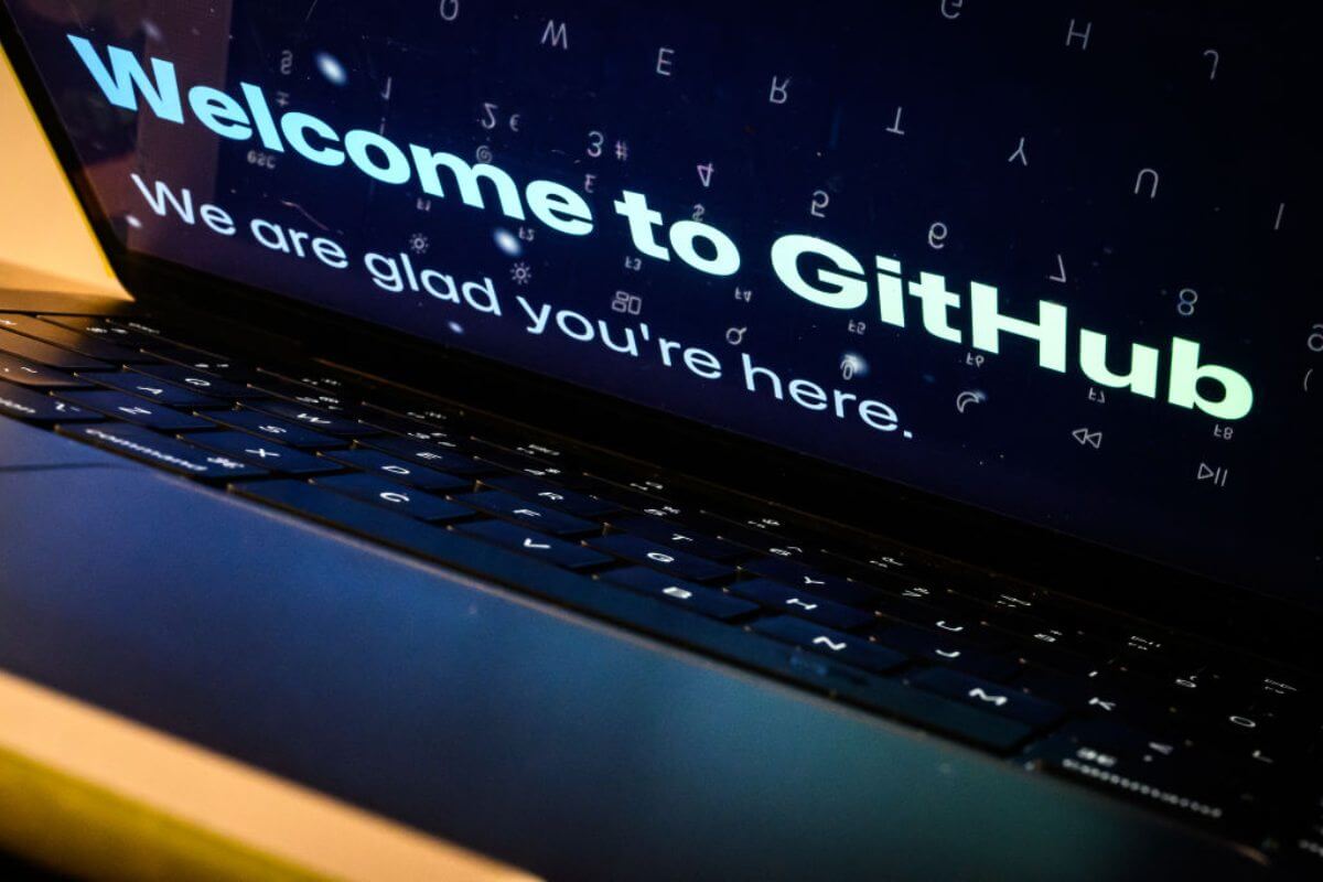 Notebook com a tela semiaberta mostrando a mensagem "Welcome to GitHub. We are glad you're here". 