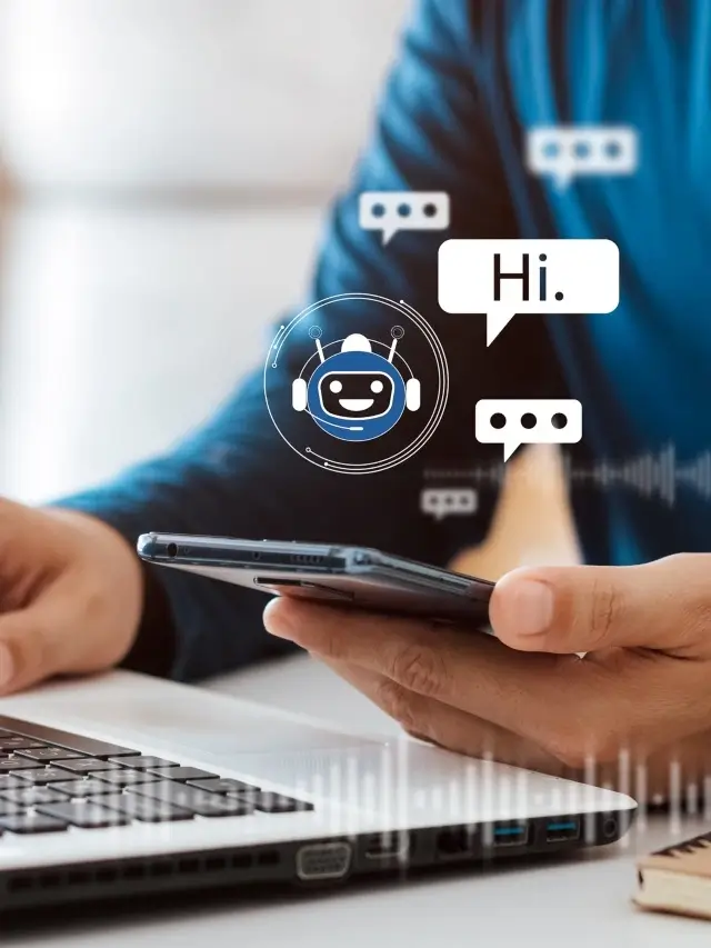 A imagem apresenta as mãos de uma mulher, ela segura um smartphone e está sentada em frente a um notebook, enquanto interage com um chatbot. Na tela, vemos a palavra "Hi.", acompanhada de diferentes balões que indicam mensagens sendo escritas.