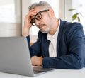 A imagem mostra um homem com expressão preocupada olhando para o notebook. Ele provavelmente está assim pelo fato de a página dele ter entrado em uma lista de sites ruins.