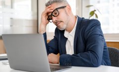 A imagem mostra um homem com expressão preocupada olhando para o notebook. Ele provavelmente está assim pelo fato de a página dele ter entrado em uma lista de sites ruins.