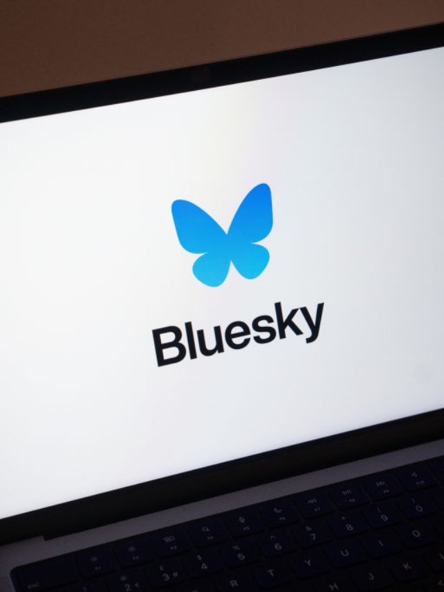 A imagem mostra o logo da rede social Bluesky — uma borboleta azul — sobre um fundo branco, na tela de um notebook.