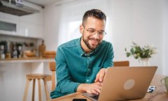 A imagem mostra um homem trabalhando em um notebook. Ele está no que parece ser a cozinha de um escritório e, possivelmente, está realizando uma busca para saber como descobrir a fonte de uma imagem na internet.