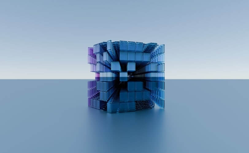 Uma ilustração apresenta um cubo sobre um fundo azul-claro, feito por outros cubos em tamanhos variados, nas cores lilás, branco, rosa e azul, representando a ideia por trás do conceito de Modular Monolith Architecture.